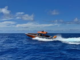 A vibrant speedboat cuts through the deep blue ocean, showcasing an exciting day on the water. Perfect for adventure seekers looking to explore the seas.