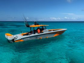 A vibrant fishing boat cruising through crystal-clear waters, showcasing its sleek design and fishing gear — perfect for adventurous outings on the sea.