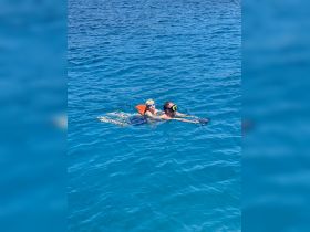 A child and an adult enjoy snorkeling together in crystal-clear waters, creating unforgettable family memories in a tropical paradise.