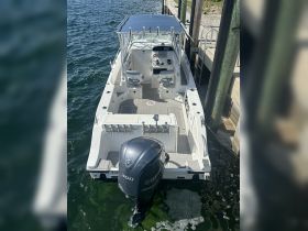 A top-down view of a sleek center console boat docked at the pier, showcasing its modern design and Yamaha engine — perfect for fishing or day cruising.
