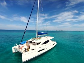 A lively group enjoys time aboard a catamaran in stunning turquoise waters, perfect for celebrations and memorable outings on the sea.