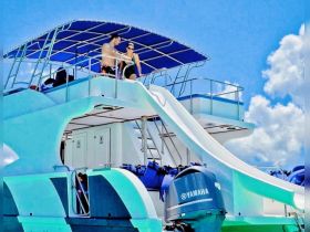 A fun boat featuring a water slide, perfect for adventurous outings on the water. Enjoy the thrill of sliding into the sea from this spacious vessel.