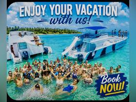 A vibrant group of vacationers enjoys a fun day in the water, celebrating aboard two boats in a tropical paradise — perfect for group outings and memorable experiences.