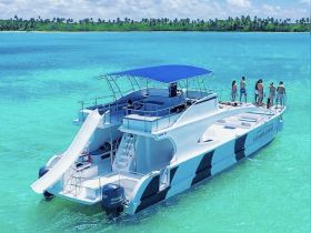 A lively group enjoys a fun day on a boat with a slide, surrounded by stunning turquoise waters — perfect for summer adventures and group outings.