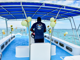 A view of the helm area inside a decorated boat, showcasing a captain at the wheel with vibrant blue interiors — perfect for private charters and excursions.