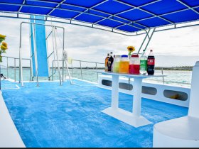 A vibrant setup of drinks and refreshments on a boat, perfect for a fun day on the water. The colorful display invites guests to enjoy cocktails and soft drinks while cruising.