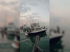 A lively group boards a fishing boat at sunset, ready for an adventure on the water — perfect for fishing trips and family outings.