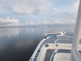 A serene view from the front of a boat, showcasing calm waters and a beautiful sky — perfect for a peaceful day on the water.