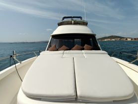 A cozy lounge area on a yacht featuring plush cushions, perfect for relaxing while enjoying scenic views on the water.