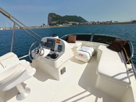 An inviting view of the helm and seating area inside a boat, showcasing the modern console and comfortable seating, perfect for a day on the water.