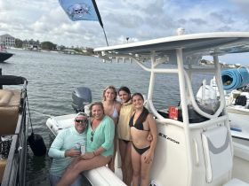 A cheerful group poses on the deck of a boat, enjoying a fun day on the water — perfect for family outings or celebrations.