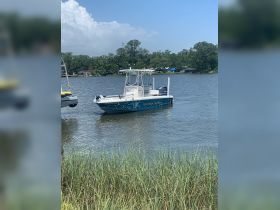A sleek speedboat is docked on calm waters, surrounded by lush greenery, perfect for fishing or leisure outings.