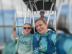 A joyful family captures a selfie aboard a boat, showcasing their adventure on the water — perfect for family outings and memorable experiences.