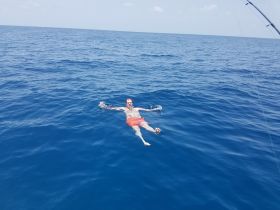 A person enjoys a refreshing swim in the deep blue ocean, capturing the essence of fun and relaxation on a boating adventure.