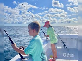 Two children enjoy a fishing trip on the open ocean, showcasing the joy of family bonding and outdoor adventures on the water.