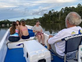 A family enjoys a relaxing moment on a boat, surrounded by serene waters and lush greenery — perfect for creating lasting memories on the water.