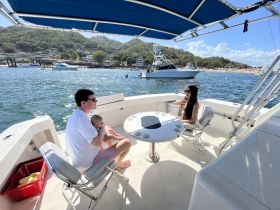 A family enjoys a relaxing moment on a boat, with stunning waterfront views in the background — perfect for creating cherished memories on the water.