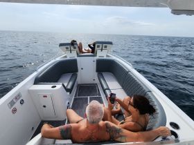 A couple enjoys a relaxing day on a boat, soaking up the sun and taking in the ocean views — perfect for a serene getaway on the water.