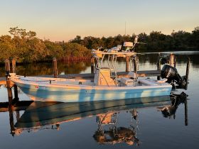 A beautiful shot of a boat docked at sunset, reflecting on calm waters — perfect for fishing or leisurely outings.