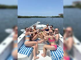 A lively group of friends enjoys a fun day on the water, toasting cocktails aboard a boat — perfect for summer celebrations and memorable outings.