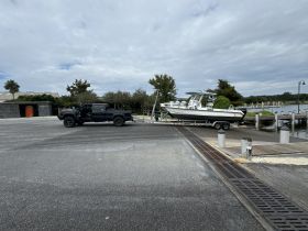 A fishing boat is being loaded onto a trailer at the dock, showcasing the process of preparing for a day on the water.