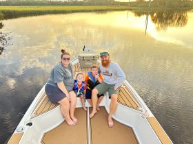 A joyful family enjoys a sunset moment on their boat, creating cherished memories with kids in life jackets — a perfect family outing on the water.