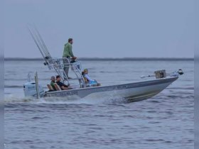 A group of anglers enjoying a fishing trip aboard the 'Falling Tide' boat, showcasing the excitement of on-water activities.