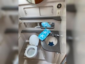 A clean and functional bathroom interior on a boat, featuring a toilet and sink area, ideal for comfort during marine trips.