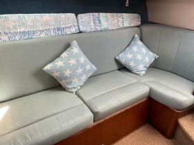 Cozy seating area inside a boat cabin, featuring starfish-patterned cushions, perfect for relaxing during your nautical adventures.