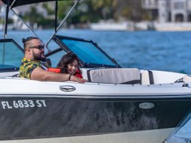 A joyful moment on the water as a man and a child enjoy a boat ride, showcasing the fun of family outings on the water.