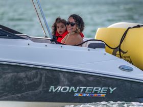 A joyful moment captured on a Monterey boat with a mother and her child enjoying a fun day on the water, showcasing family bonding and adventure.