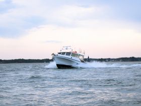 A sleek speedboat glides through the water, showcasing its dynamic design and performance. Perfect for adventure seekers looking to explore the open waters.