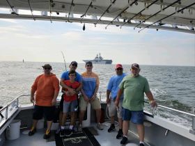 A group of friends and family enjoy a fishing trip aboard a boat, capturing moments of camaraderie and adventure on the water.