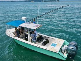 A group of friends enjoys a fishing trip aboard a well-equipped boat, showcasing the excitement of on-water activities in a beautiful setting.