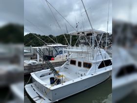 A fishing boat docked at the marina, showcasing its spacious deck and fishing gear — perfect for deep-sea fishing adventures.