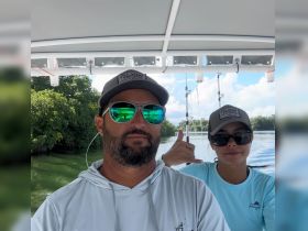 A couple enjoys a fishing trip on a boat, showcasing a fun outdoor adventure in a scenic setting.