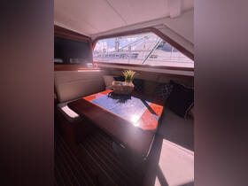 A cozy interior view of a boat's cabin featuring a dining area with a stylish table and decorative elements, perfect for relaxing during a sailing adventure.