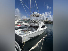 A sleek yacht docked at the marina, showcasing its impressive structure against a clear blue sky — perfect for fishing or leisure outings.