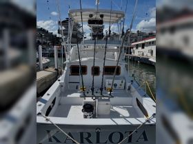 The interior of the fishing boat 'KARLOTA' showcases a well-equipped helm area with fishing rods ready for an adventure on the water.