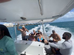A lively group enjoys drinks aboard a boat, capturing the essence of a fun day on the water with friends.