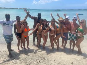 A lively group celebrates at the beach, enjoying drinks and sunshine — perfect for unforgettable summer adventures.