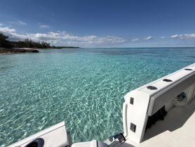 A stunning view of a boat anchored in crystal-clear waters, showcasing the serene beauty of the surrounding coastline — perfect for a day of relaxation on the water.