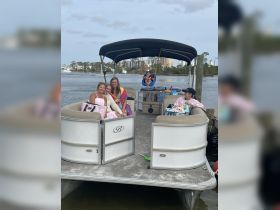 A joyful group enjoys a day on a pontoon boat, capturing moments of fun and relaxation on the water with family and friends.