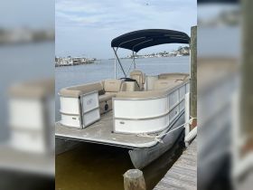 A stylish pontoon boat docked at the marina, showcasing its spacious seating and sleek design, perfect for leisurely outings on the water.