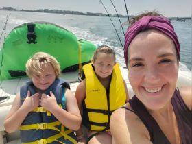 A joyful family enjoys a day on the water, with kids wearing life jackets and smiles all around — perfect for creating lasting memories on a boat trip.