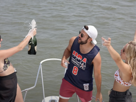 A lively group celebrates on a boat, popping champagne and enjoying the sun — perfect for festive gatherings and memorable outings on the water.