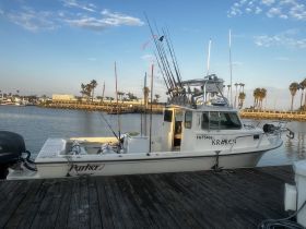 A well-equipped Parker fishing boat named 'KRACKEN' docked at the marina, showcasing its fishing gear and sturdy design — perfect for deep-sea adventures.
