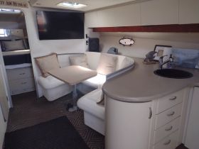 Interior view of a cozy boat cabin featuring a comfortable seating area and dining space, perfect for relaxing during a day on the water.