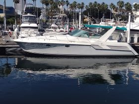 A sleek yacht docked at the marina, showcasing its elegant design and reflections in the calm water — perfect for luxury charters and day trips.