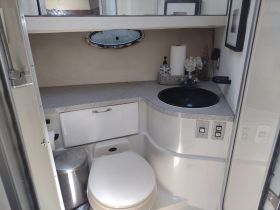A clean and well-appointed boat bathroom featuring a modern sink and toilet, ideal for comfort on the water.
